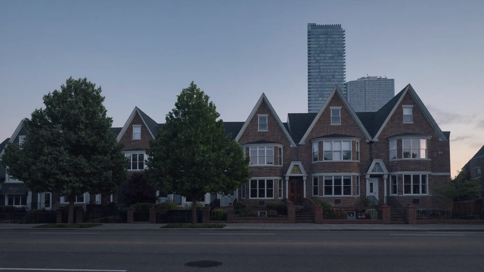 A quiet Toronto residential street at dawn, brick houses in the foreground and glass towers behind